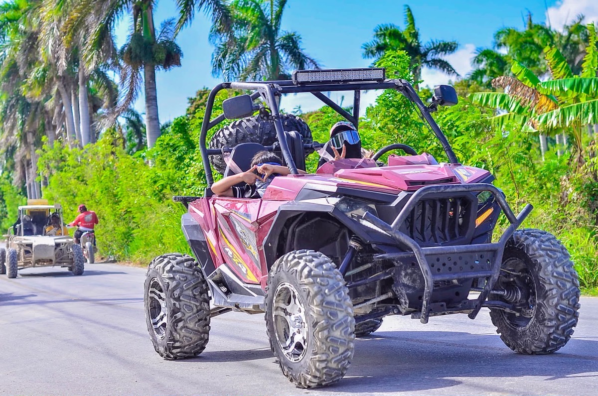 Buggy de frente por la carretera, con otro detrás entre palmeras