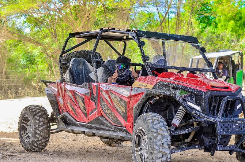 Buggy rojo con sus ocupantes, con casco y pañuelo