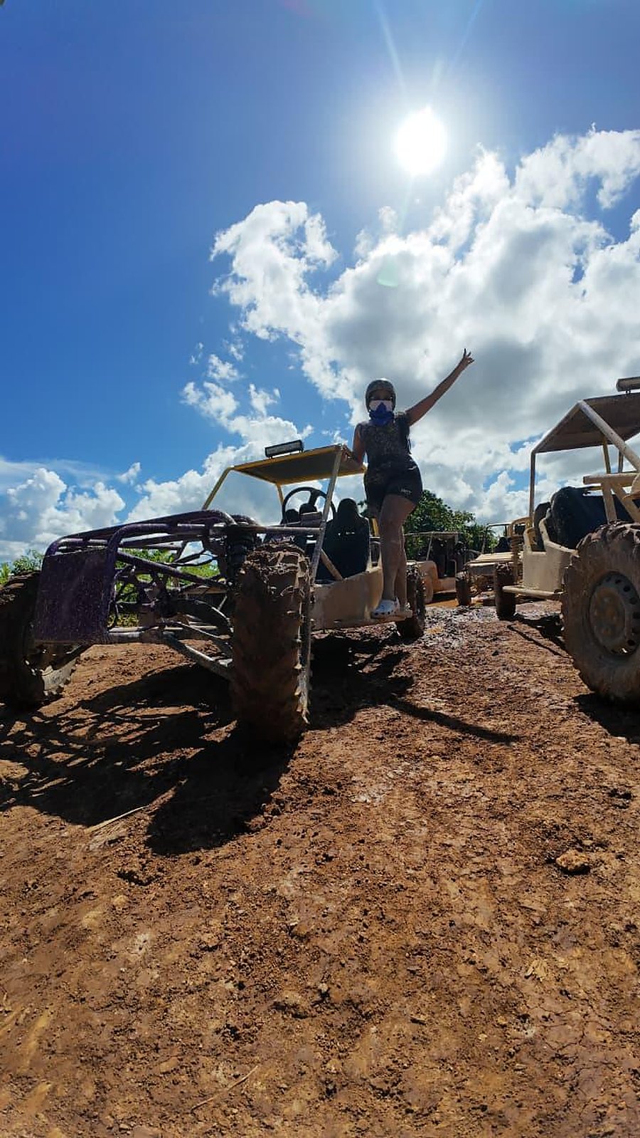 Una viajera de pie sobre su buggy, con los brazos en alto bajo el sol