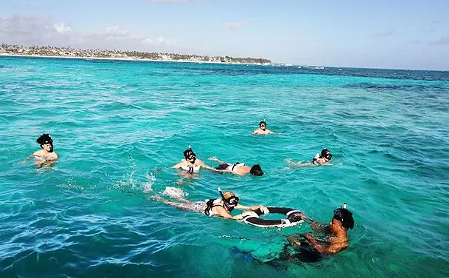 Viajeros haciendo snorkel en agua turquesa