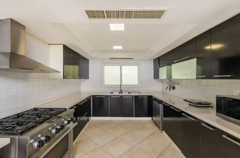 Cocina con isla, campana y encimeras oscuras