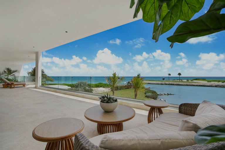 A living room with floor-to-ceiling glass over the lagoon
