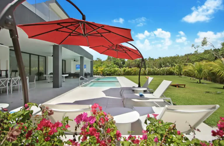 The terrace with a parasol, the pool and the garden