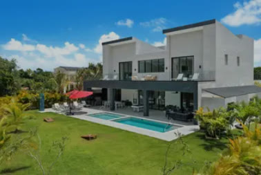 The modern mansion with its pool and lawn