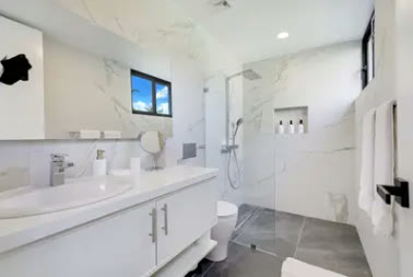 A marble bathroom with a double basin and shower