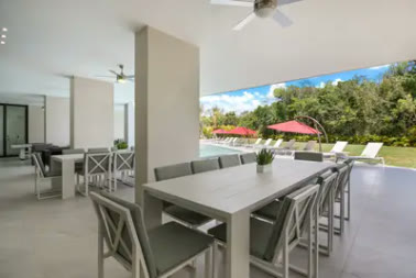 A covered outdoor dining area facing the garden