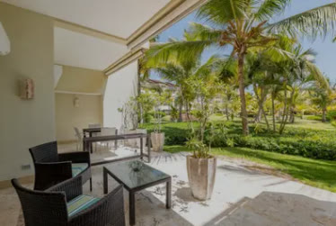 A terrace with a table and chairs among palm trees