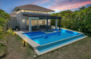 La villa de noche con la piscina iluminada