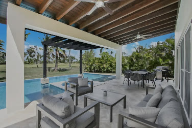 Terraza cubierta con sofás junto a la piscina