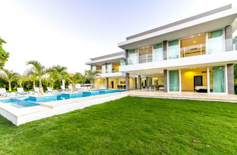 The modern villa with its pool and lawn
