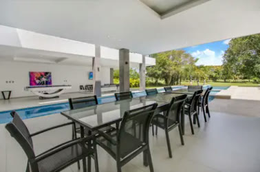 Comedor exterior con mesa larga junto a la piscina