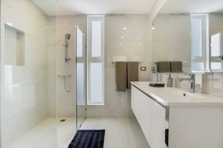 Baño blanco con ducha de obra