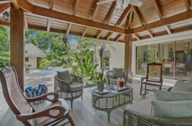 Gazebo de madera con sillones junto a la piscina