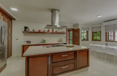 A wooden kitchen with an island and extractor hood