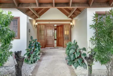The villa entrance with plants and a wooden ceiling